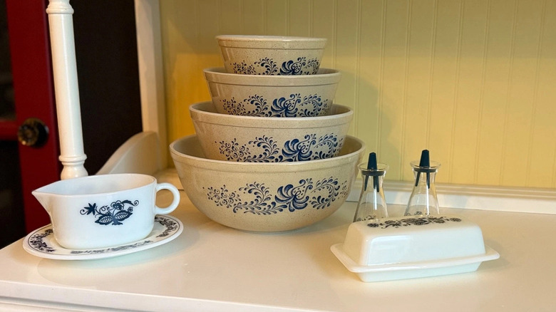 Vintage Pyrex bowls, gravy bowl, and butter dish in 'Homestead' and 'Old Town Blue' patterns.
