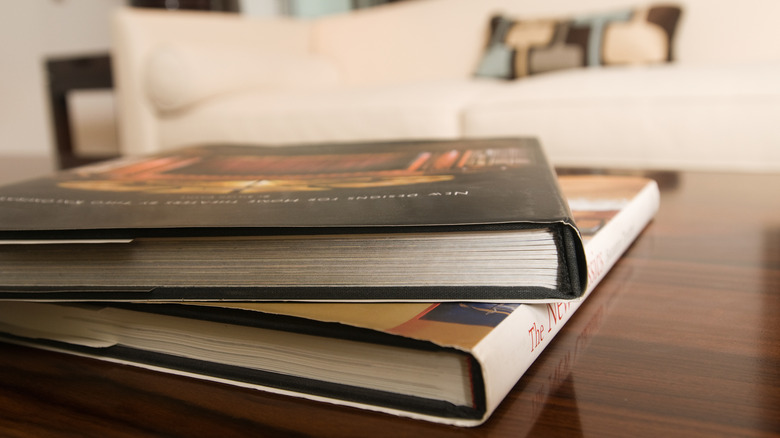 Two coffee table books with a white sofa in the background