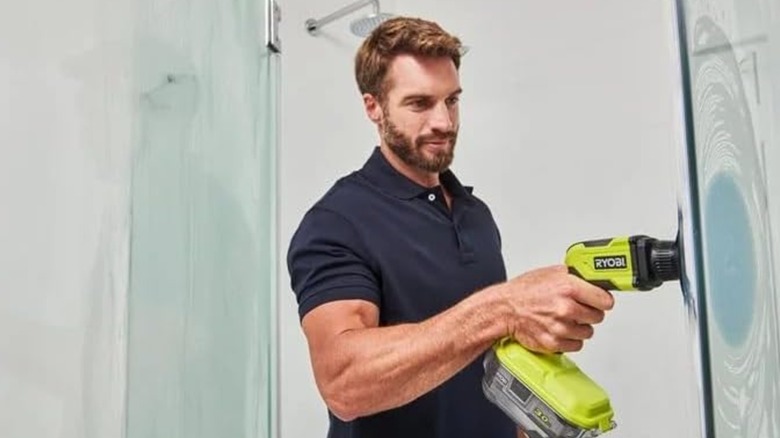 Person using a Ryobi Vortex scrubber on a shower wall