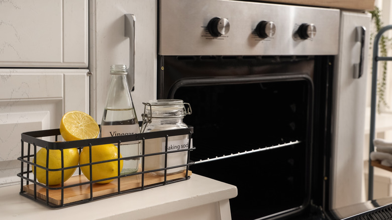 natural cleaning supplies with lemons on stool near oven in kitchen