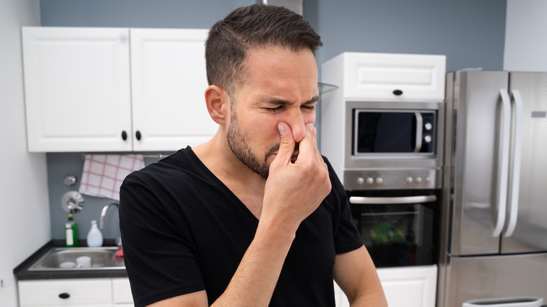 man smelling something bad kitchen