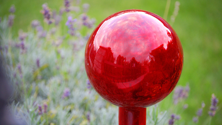 A bright red gazing ball in a garden