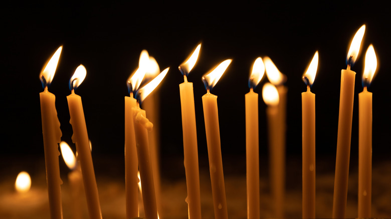 tapered candles lit up in a dark room