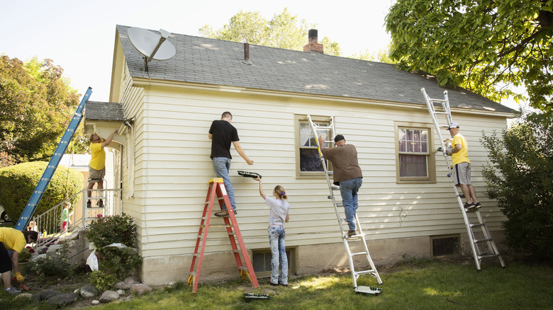 a family paint a house's exterior