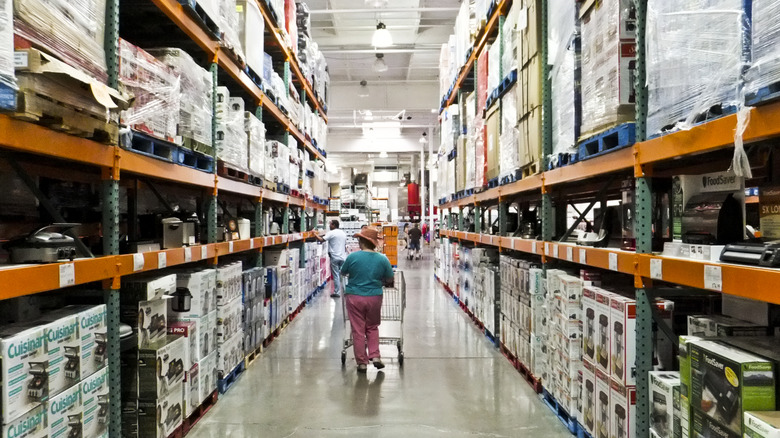 a woman shopper walks an aisle at Costco