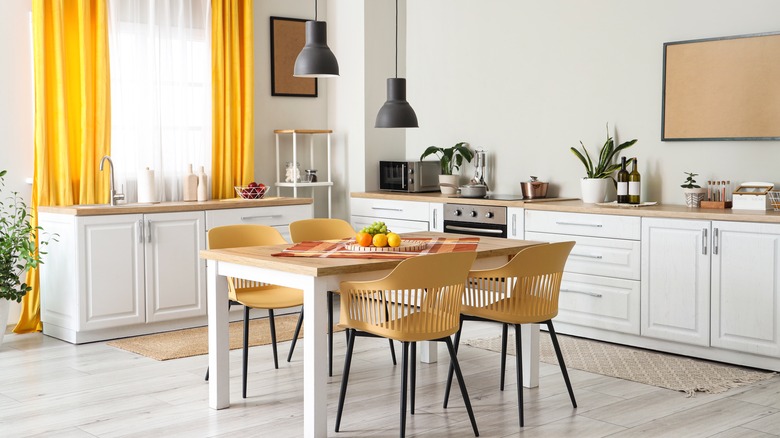 Neutral kitchen with yellow curtains and dining chairs