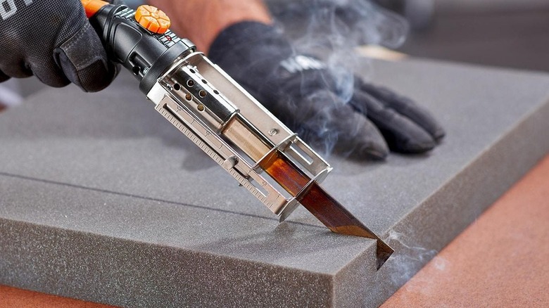 Man's hand cutting through foam with Warrior hot knife