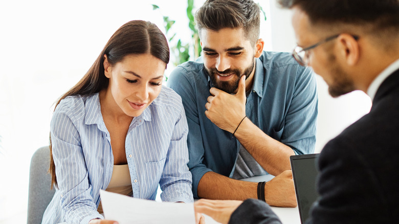 A real estate agent looks over an offer with a couple