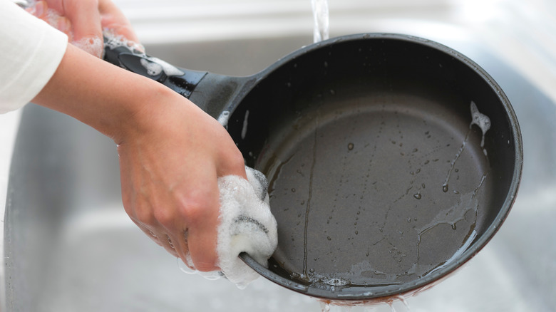 Person washing a frying pan