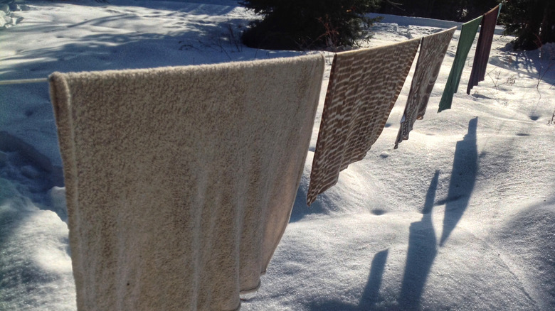 Blankets hang on a clothesline in winter.