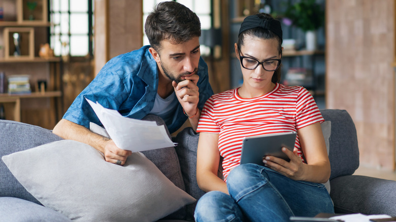 Couple contemplating issue on laptop