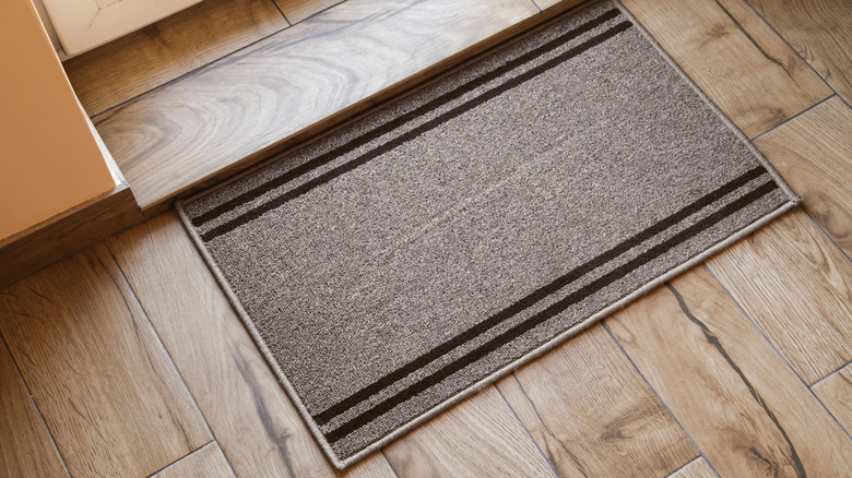 Entryway doormat on wooden floor for catching dirt, water, and dust
