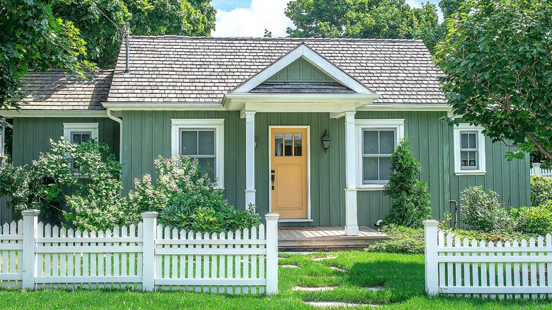 Olive-green home with picket fence
