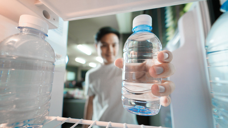 grabbing water bottle from fridge