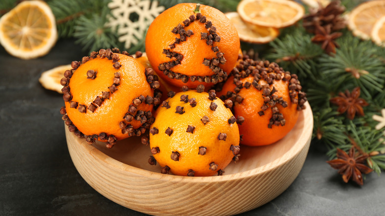 Oranges studded with cloves to make pomanders for a scented holiday decoration