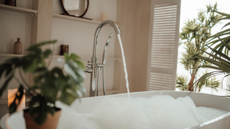 A sleek bathtub filled with bubbles and water