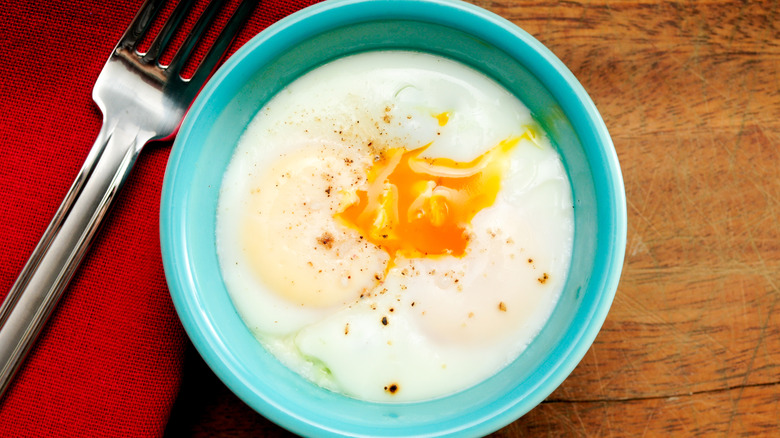 Poached egg in blue ramekin with fork
