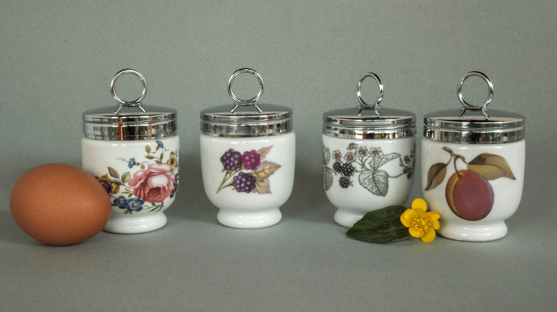 Set of four porcelain egg coddlers with egg and flower