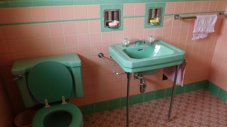 1950s bathroom built in with colored sink and toilet and pink tile
