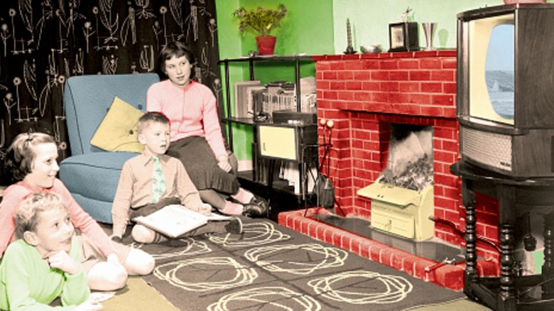 Family watching TV around a patterned rug