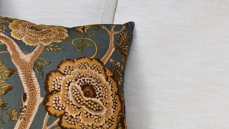 throw pillow made with embroidery material on plain sofa