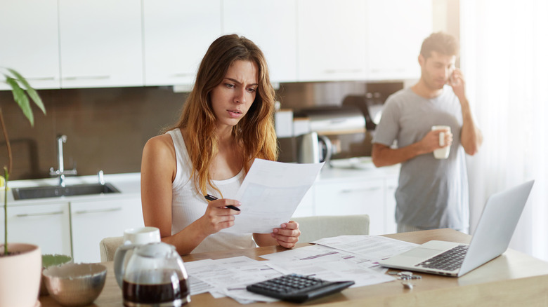 Woman going through a pile of documents in the kitchen