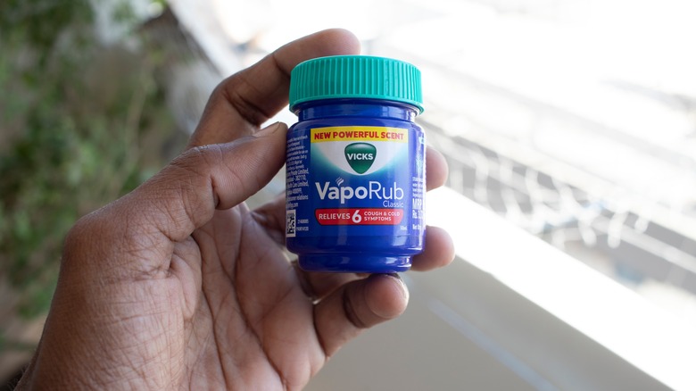Vicks VapoRub bottle in hand close up