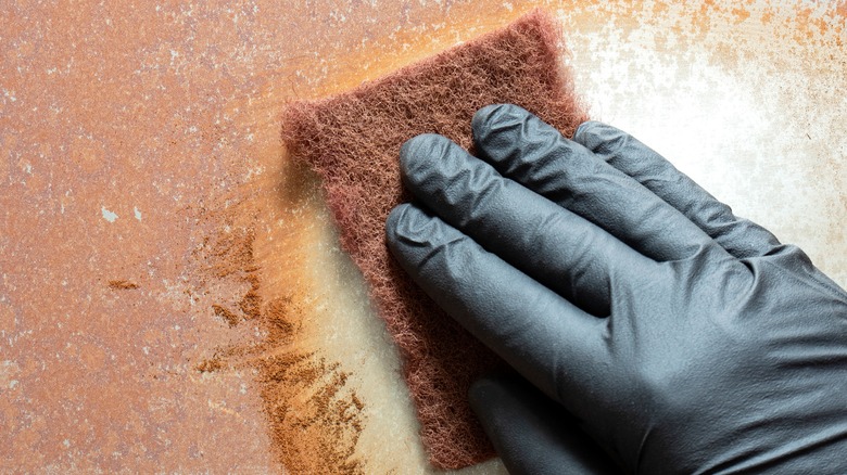 wiping rusty surface with cloth 