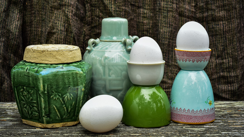 Eggs in egg cups next to other tiny bowls and coddlers