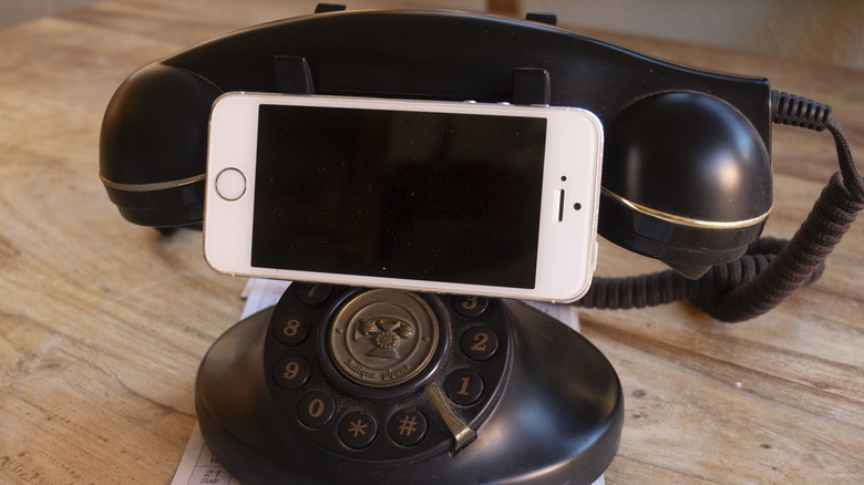 Old rotary phone holding an iPhone