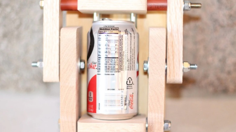 Wooden can crusher with silver aluminum can inside