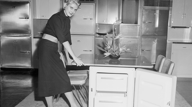 A 1950s black and white ad shows a model posing with a Revco Dinette Freezer