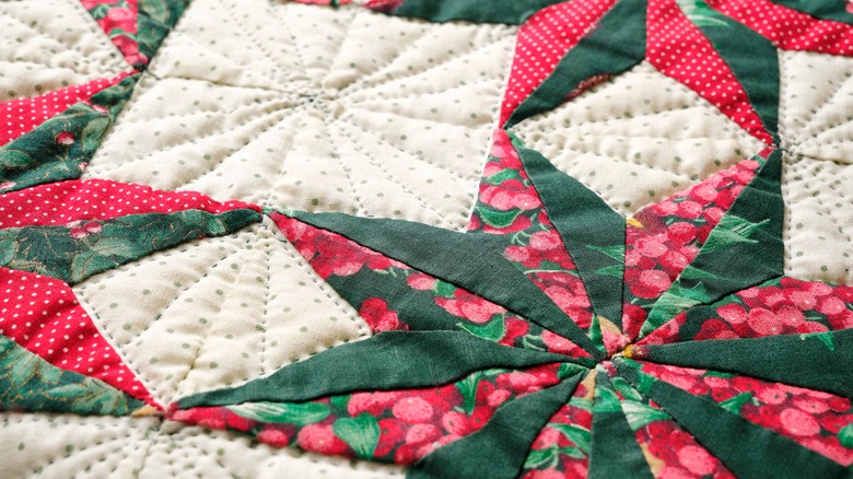 Close up on a festive holiday quilt with green and red star pattern