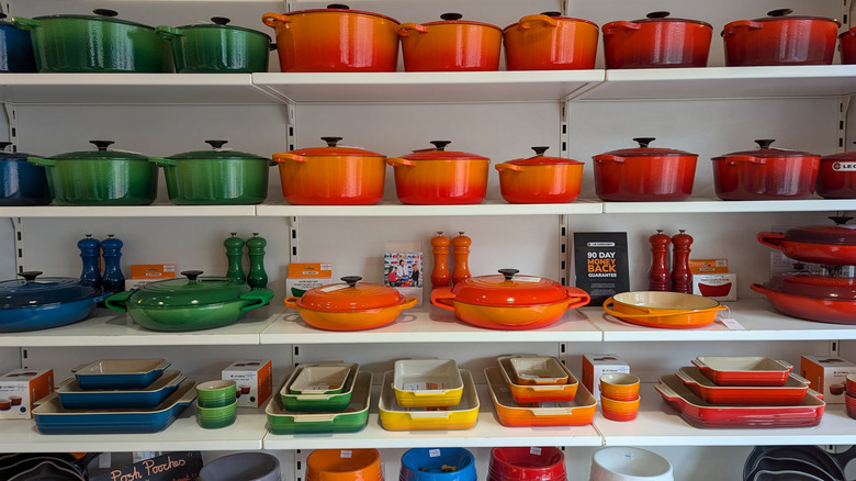 A display of Le Creuset pots and pans in a variety of shades