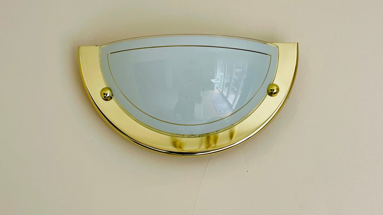 Modern brass wall light fixture with frosted glass