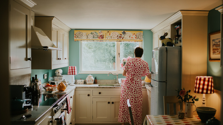 Woman doing chores in an intimate and stylish closed-concept kitchen