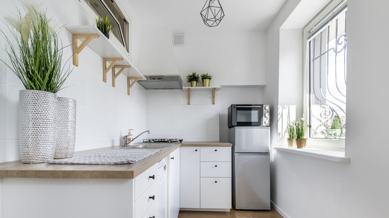Stylish closed concept kitchen with L-shaped corner cabinets and clutter-free design