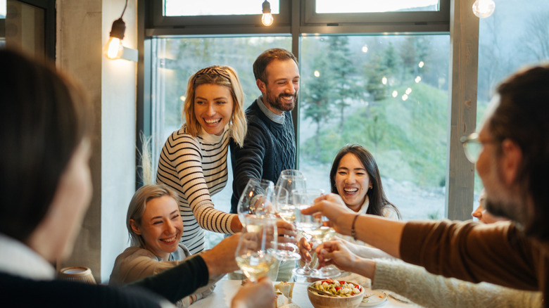 A group toasts during a meal together