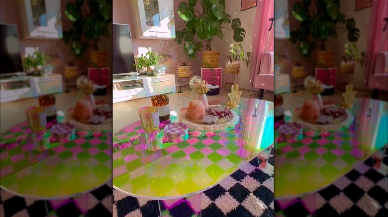 A pink, retro-styled living room with an acrylic coffee table.