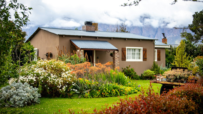 A native wildflower garden surrounds a brown house