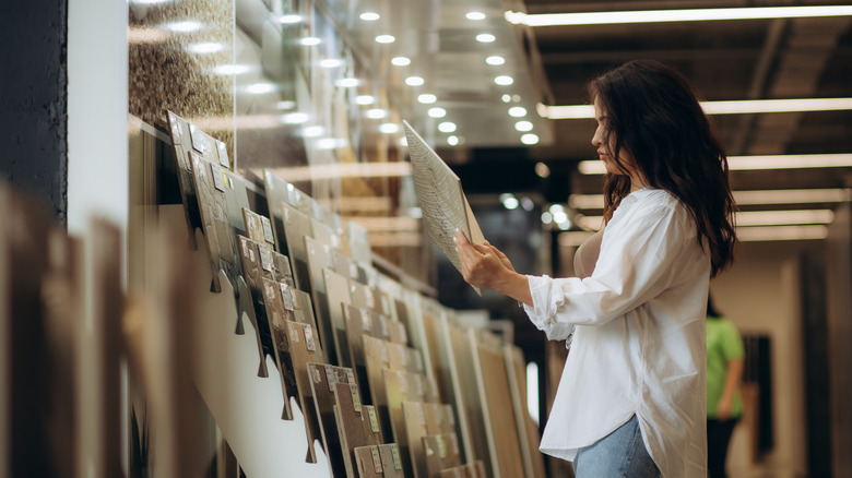 A woman looking at tile samples at the store