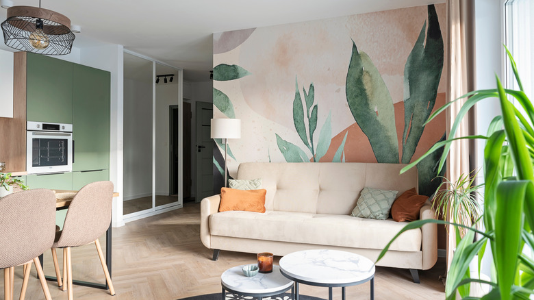 Living room with feature wall covered in plant-themed wallpaper