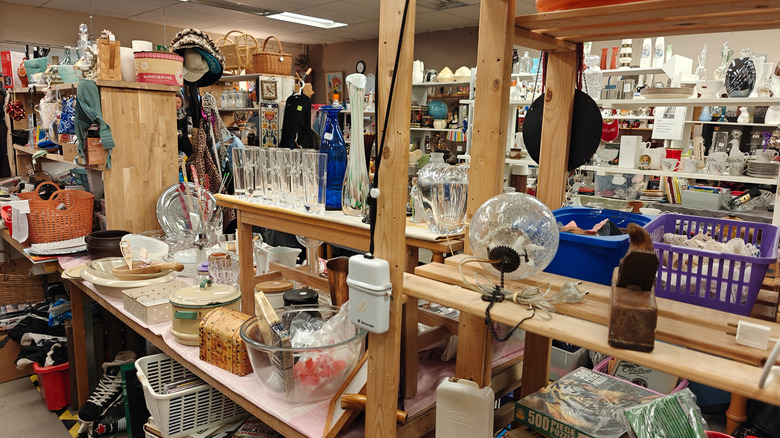 Shelves at a thrift store that are full of housewares.