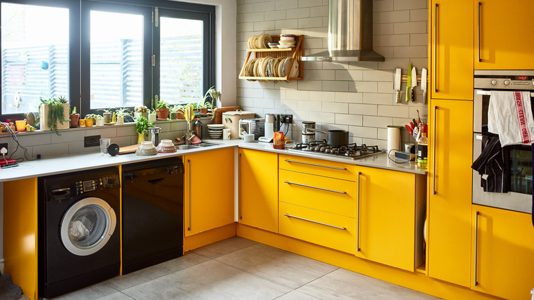 Kitchen featuring bright yellow cabinets with black and white accents