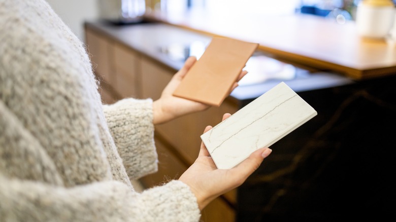 Woman holding samples of countertop materials