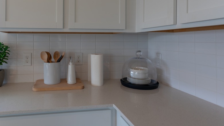 Kitchen with Corian countertop and white cabinets