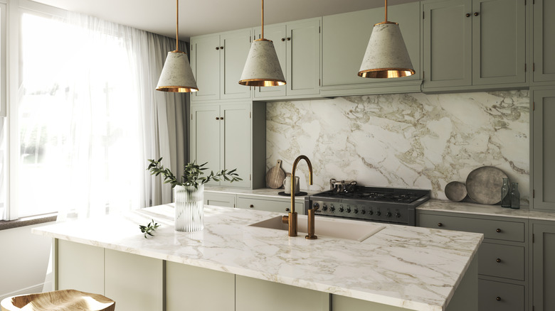 Ash-colored wooden cabinets with marble island in a kitchen