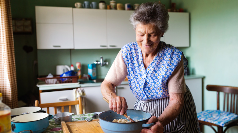 A senior female working in a dated kitchen