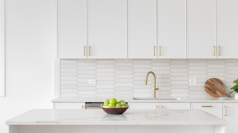 A boring all-white kitchen with golden hardware