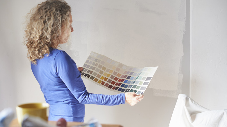 Woman choosing paint samples from a wide sheet of paper